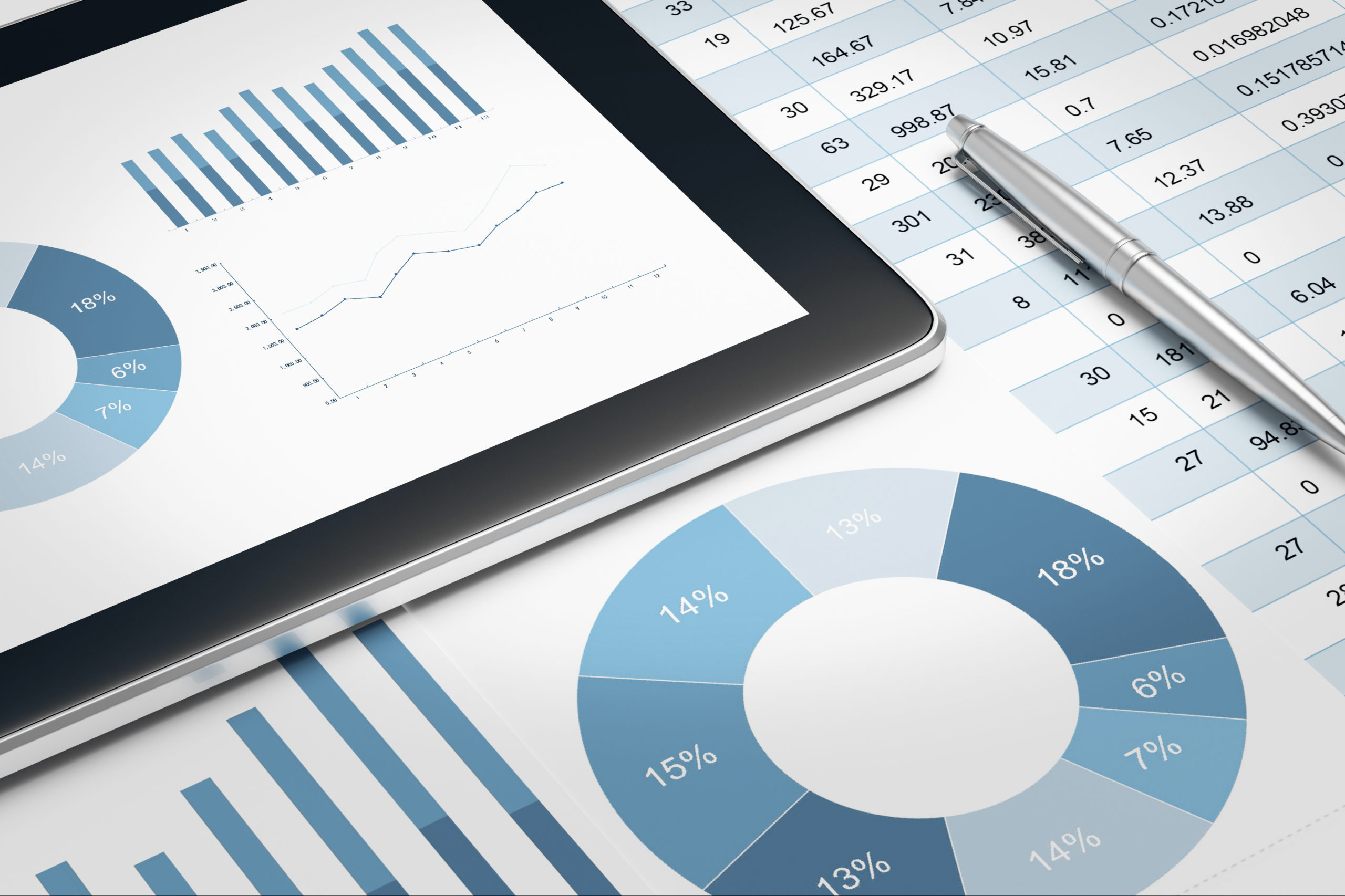 Graphiques financiers sur tablette et documents d’analyse, représentant la digitalisation des données d’entreprise.